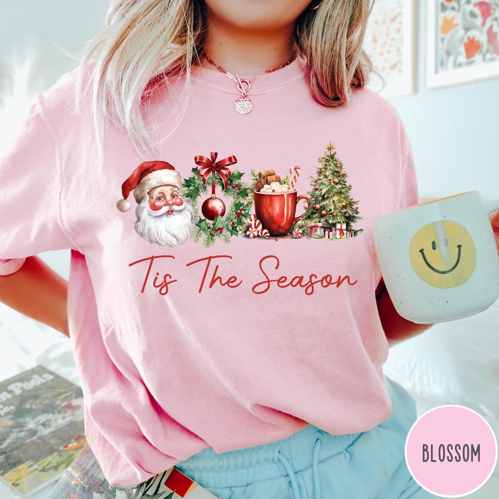 Comfort Colors tee in Blossom featuring holiday design with Santa, wreath, hot cocoa, and Christmas tree graphic