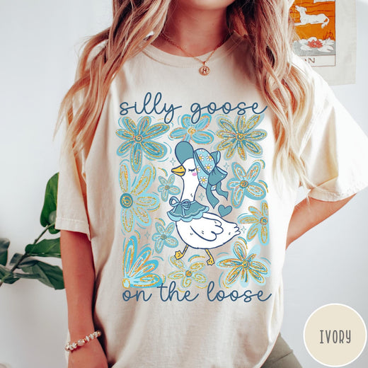 Comfort Colors tee in Ivory featuring whimsical graphic style with a goose wearing a bonnet and floral border