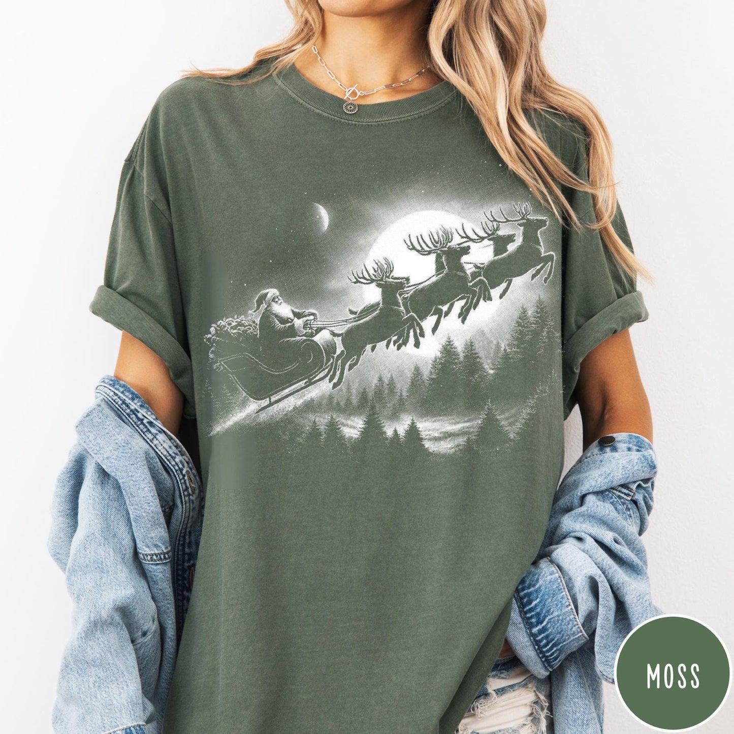 Comfort Colors tee in Moss featuring vintage style graphic of Santa Claus flying his sleigh with reindeer