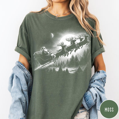 Comfort Colors tee in Moss featuring vintage style graphic of Santa Claus flying his sleigh with reindeer