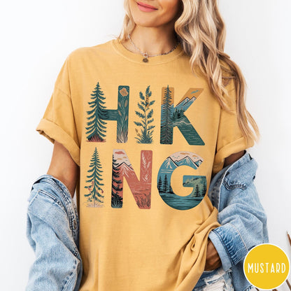 Comfort Colors tee in Mustard featuring nature graphic with trees and mountains inside the word Hiking