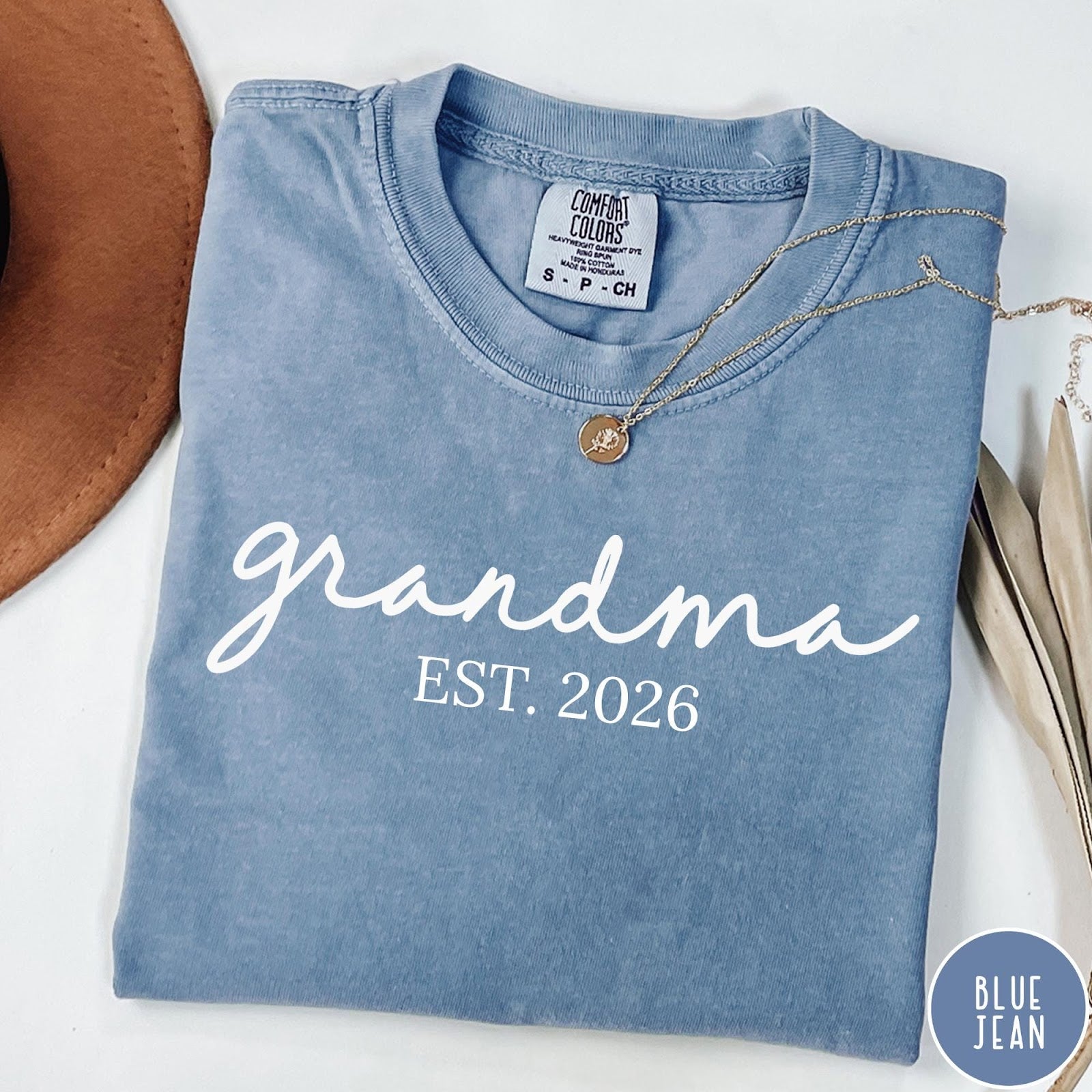 Comfort Colors tee in Blue Jean featuring cursive Grandma Est 2026 text in a clean white graphic style