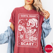 Comfort Colors tee in Crimson featuring graphic design of a skeleton in a Santa hat holding cocoa