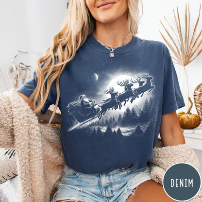 Comfort Colors tee in Denim featuring vintage style graphic of Santa Claus flying his sleigh with reindeer