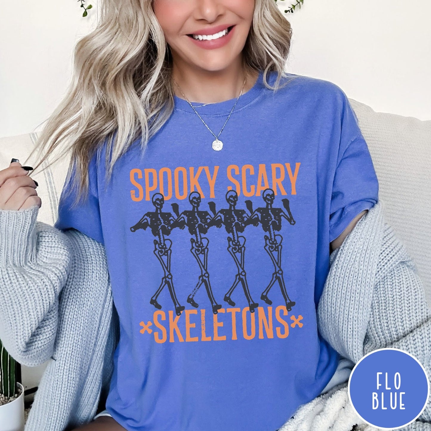 Comfort Colors tee in Flo Blue featuring dancing skeletons graphic with Spooky Scary Skeletons text in orange