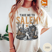Comfort Colors tee in Ivory featuring vintage style Salem town scene with black cat and pumpkins