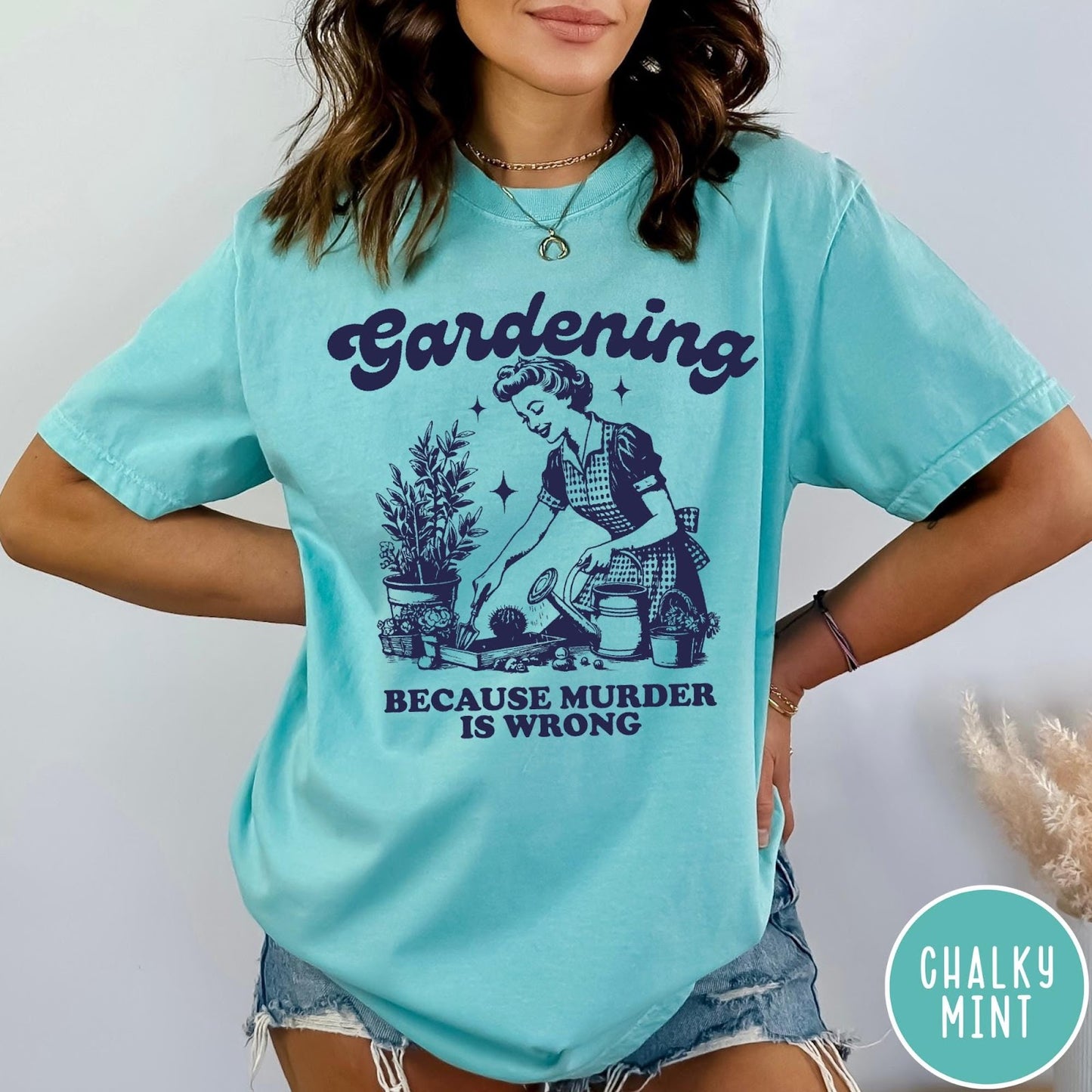 Comfort Colors tee in Chalky Mint featuring vintage style graphic of a woman gardening with text about murder.
