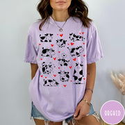 Comfort Colors tee in Orchid featuring cute cow lover graphic with various black and white cow illustrations