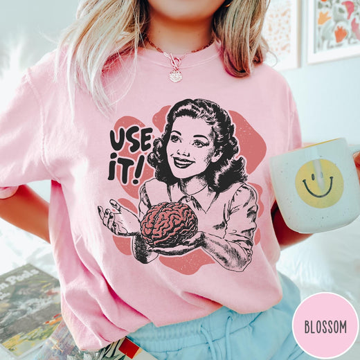 Comfort Colors tee in Blossom featuring retro style graphic of a woman holding a human brain