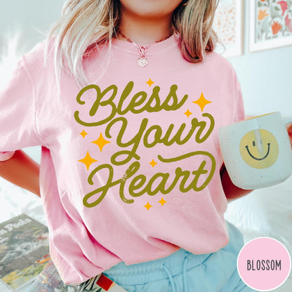Comfort Colors tee in Blossom featuring script lettering and star accents with the phrase Bless Your Heart