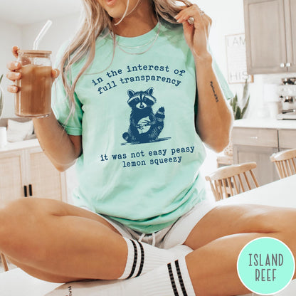 Comfort Colors tee in Island Reef featuring screen printed raccoon graphic and text about full transparency and lemons