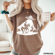 Comfort Colors tee in Espresso featuring western graphic style cowboy on horseback being abducted by a UFO