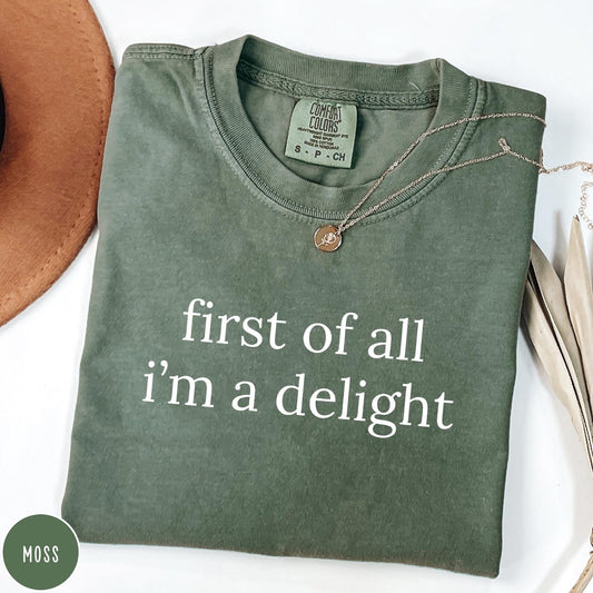 Comfort Colors tee in Moss featuring typography graphic reading first of all i'm a delight in white