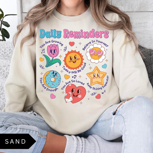Comfort Colors tee in Sand featuring retro mascot design with daily affirmations and colorful graphics