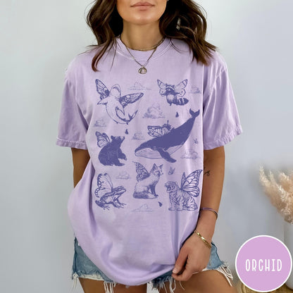 Comfort Colors tee in Orchid featuring vintage style graphic of various animals with butterfly wings and clouds