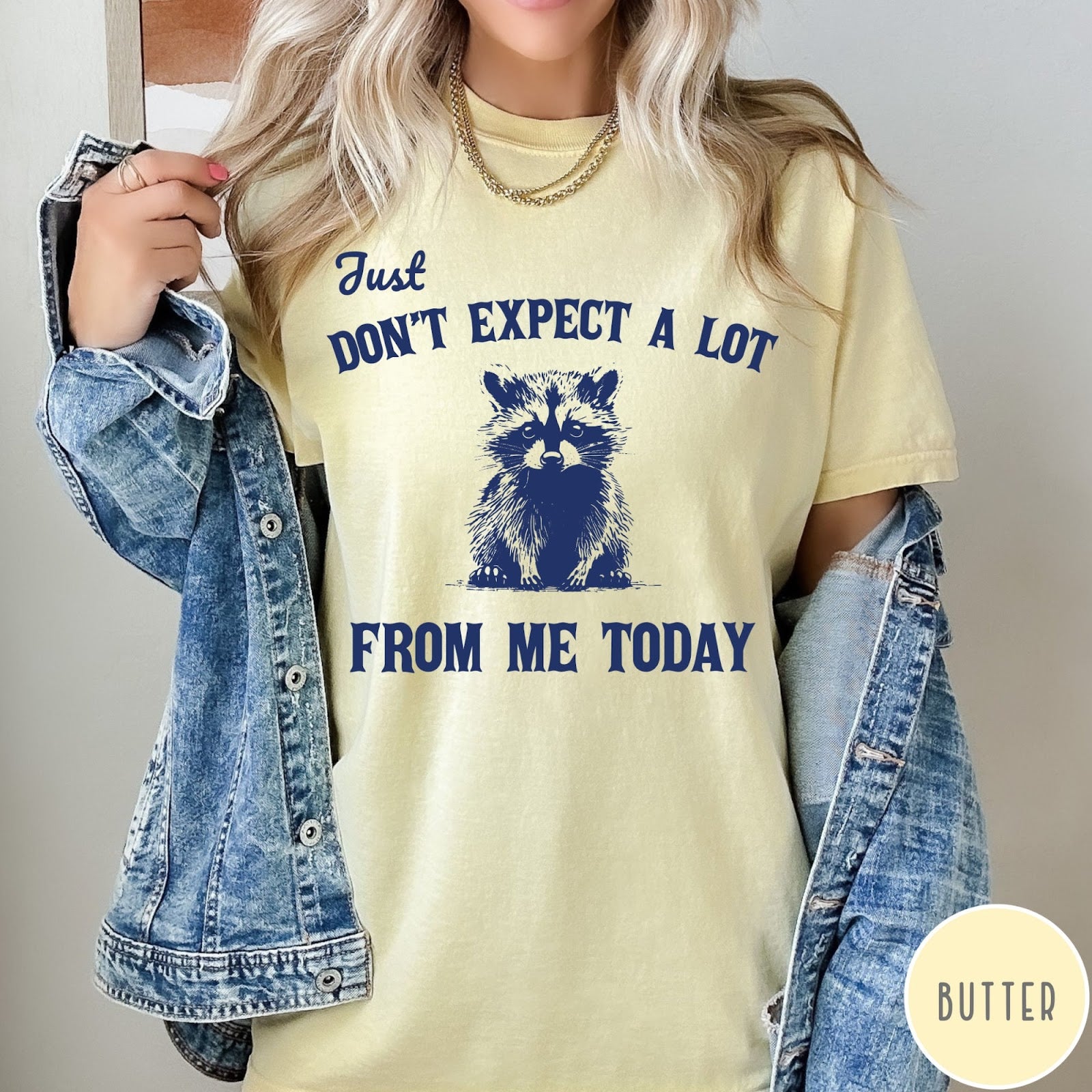 Comfort Colors tee in Butter featuring screen printed raccoon graphic and text Just Don't Expect A Lot