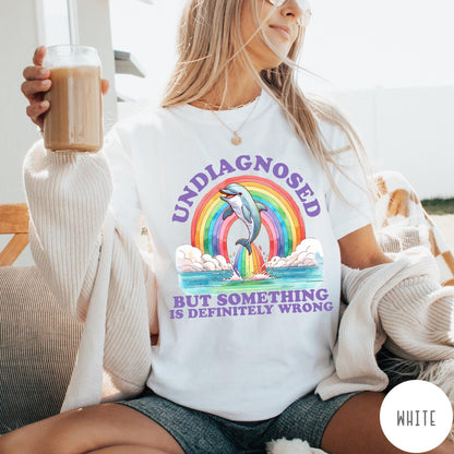 Comfort Colors tee in White featuring graphic style illustration of a dolphin jumping through a colorful rainbow