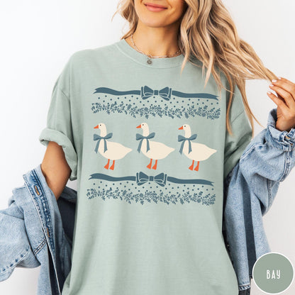 Comfort Colors tee in Bay featuring vintage style graphic with three geese wearing blue ribbons and floral borders