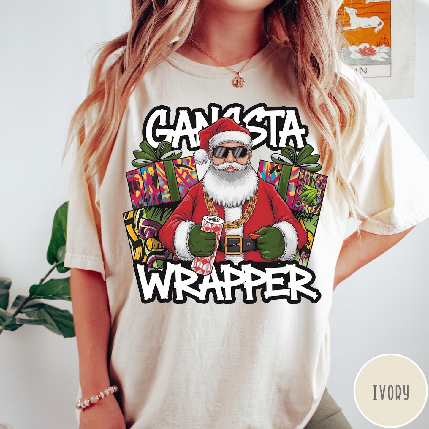 Comfort Colors tee in Ivory featuring cartoon style Santa Claus wearing sunglasses and gold chain holding wrapping paper