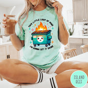 Comfort Colors tee in Island Reef featuring cartoon style graphic of a smiling dumpster fire with text