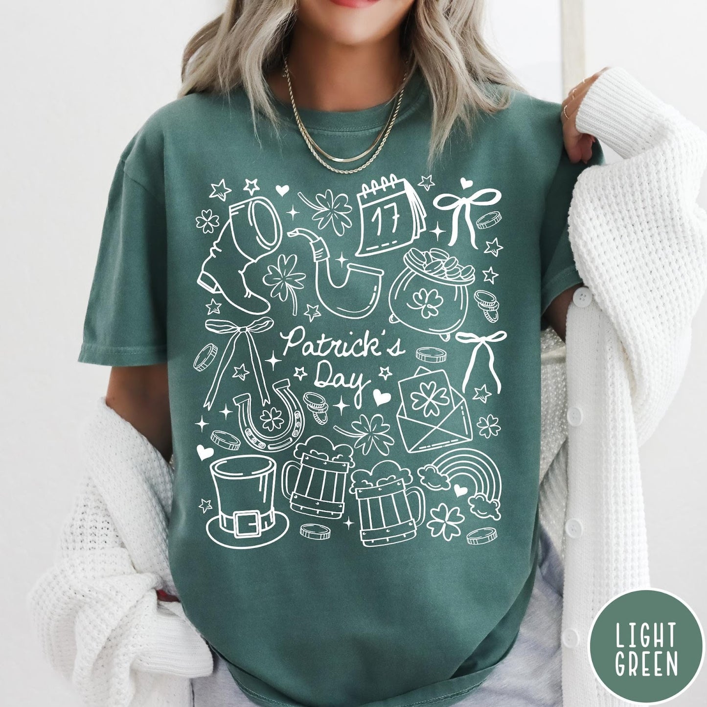Comfort Colors tee in Light Green featuring white line art style St. Patrick's Day icons including shamrocks and leprechaun hat