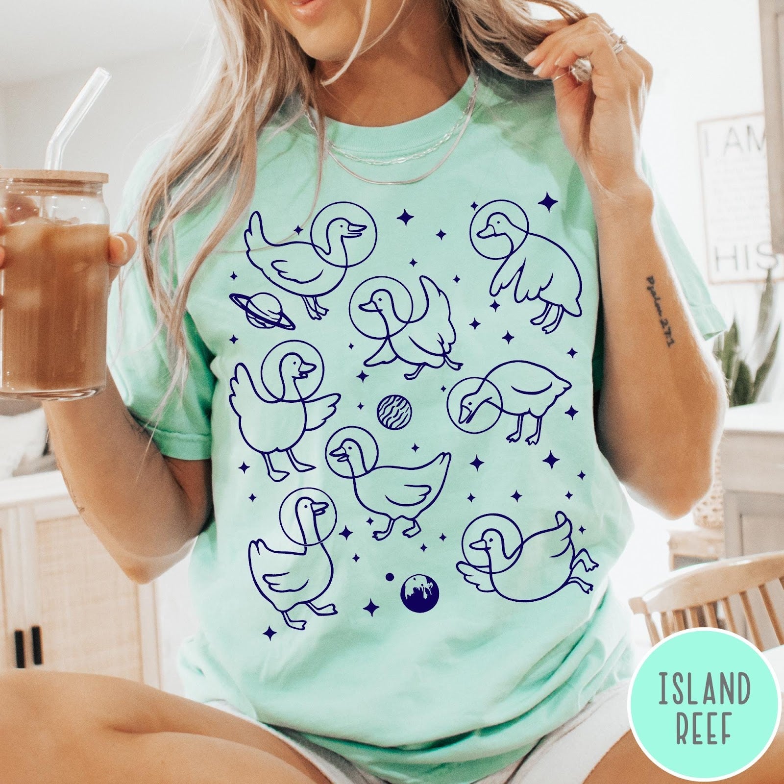 Comfort Colors tee in Island Reef featuring line art graphic of multiple geese wearing astronaut helmets in space