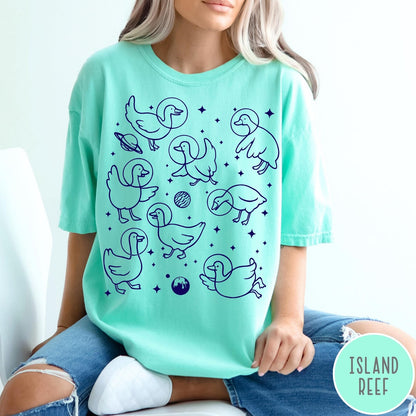 Comfort Colors tee in Island Reef featuring line art graphic of multiple geese wearing astronaut helmets in space