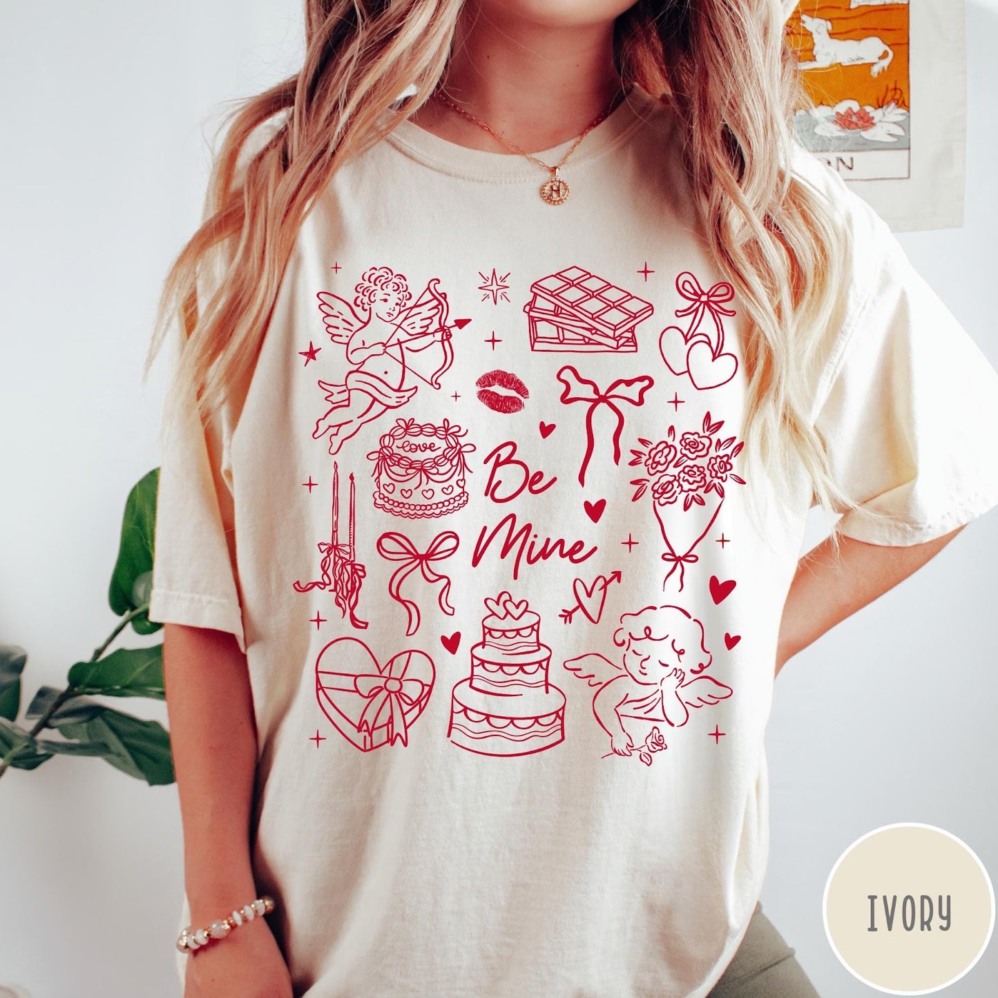 Comfort Colors tee in Ivory featuring Valentine's Day collage graphic with cupid, cakes, and romantic symbols.