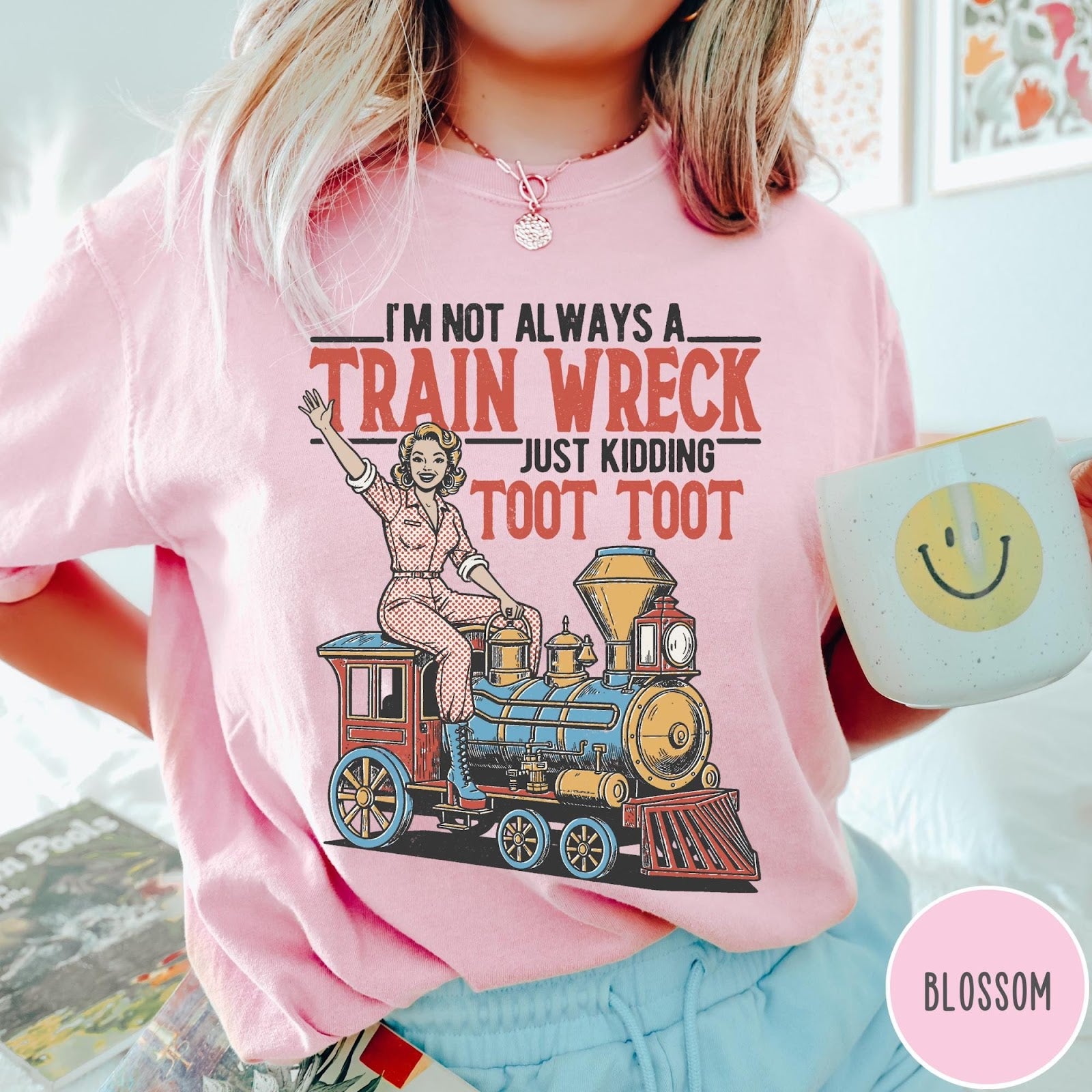 Comfort Colors tee in Blossom featuring vintage style pin-up woman sitting on a steam train graphic