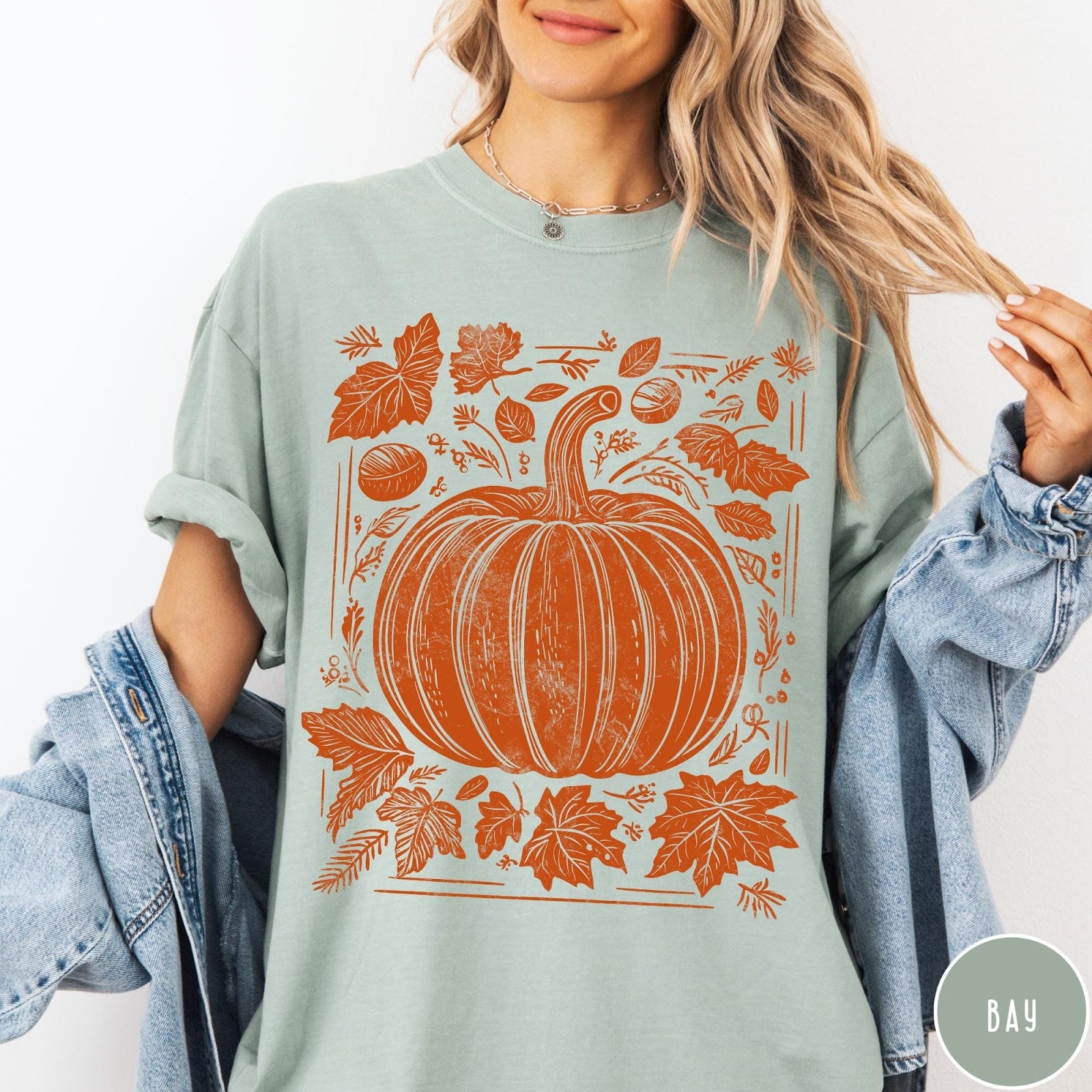 Comfort Colors tee in Bay featuring rustic pumpkin design with surrounding fall leaves and woodland elements