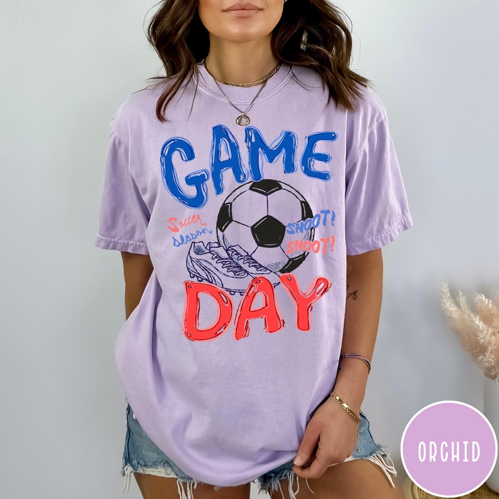 Comfort Colors tee in Orchid featuring soccer graphic with a ball, cleats, and Game Day text