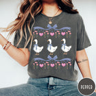 Comfort Colors tee in Pepper featuring vintage style graphic with three geese wearing blue bows and hearts