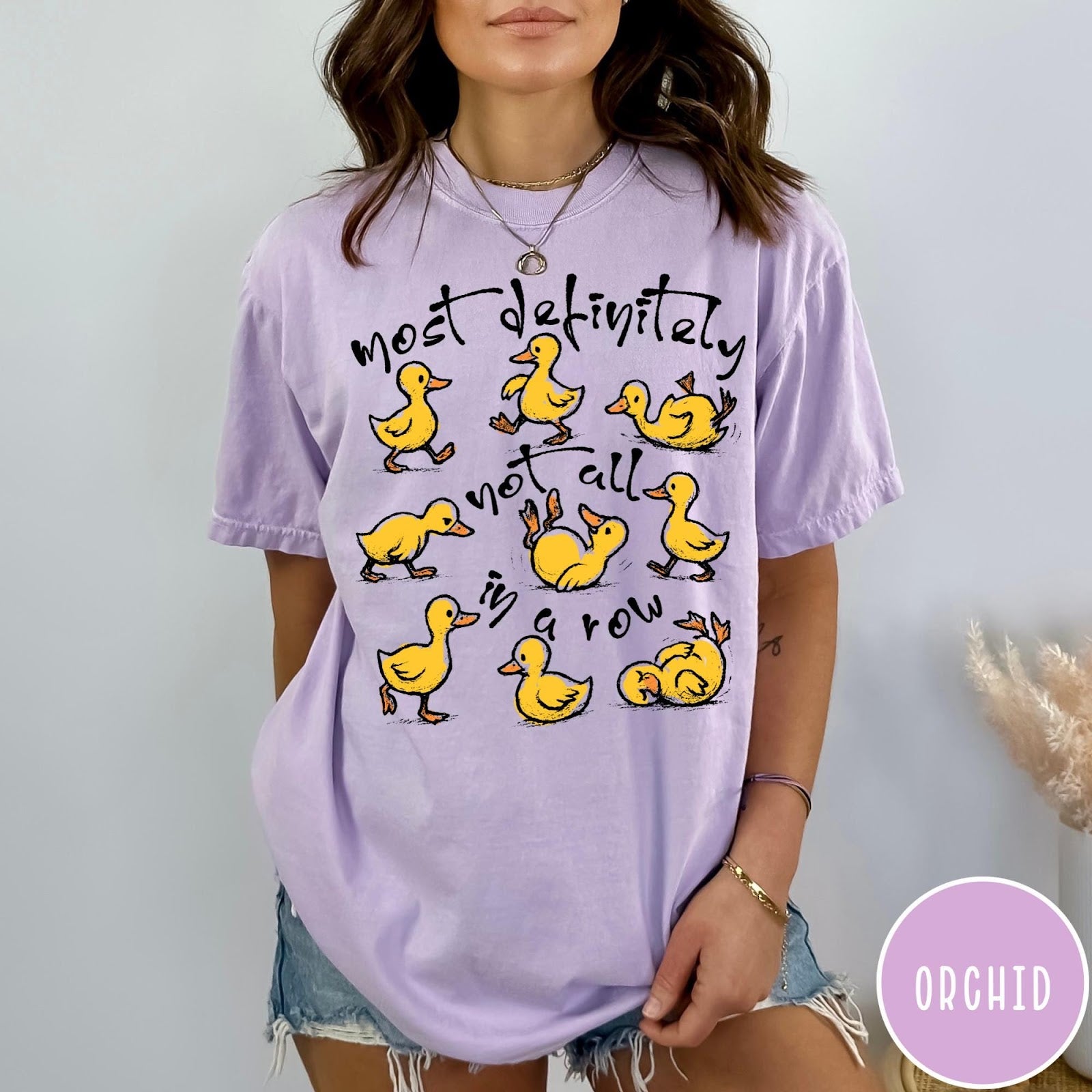 Comfort Colors tee in Orchid featuring screen print style graphic of nine yellow ducks in various poses