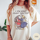 Comfort Colors tee in Ivory featuring vintage style graphic of Santa Claus kissing a woman under stars