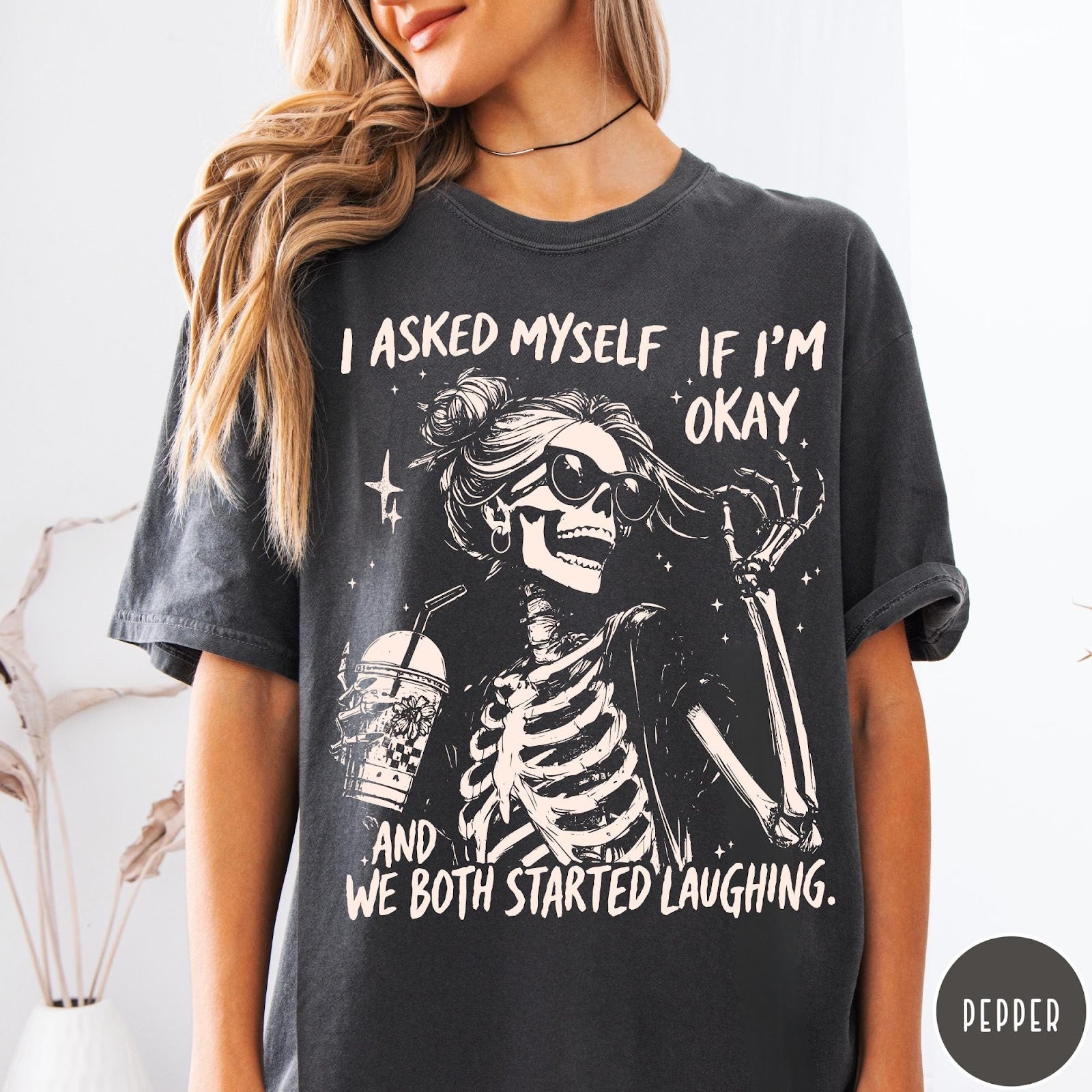 Comfort Colors tee in Pepper featuring skeleton design with sunglasses and iced coffee with laughing text graphic