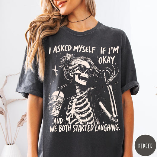 Comfort Colors tee in Pepper featuring skeleton design with sunglasses and iced coffee with laughing text graphic