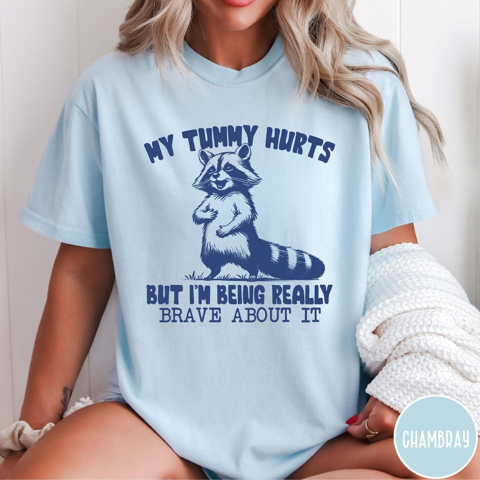 Comfort Colors tee in Chambray featuring graphic illustration of a standing raccoon with funny text about being brave