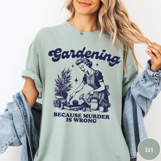 Comfort Colors tee in Bay featuring vintage style graphic of a woman gardening with text about murder.