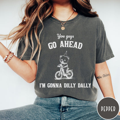 Comfort Colors tee in Pepper featuring illustration style graphic of a bear wearing a party hat riding bicycle