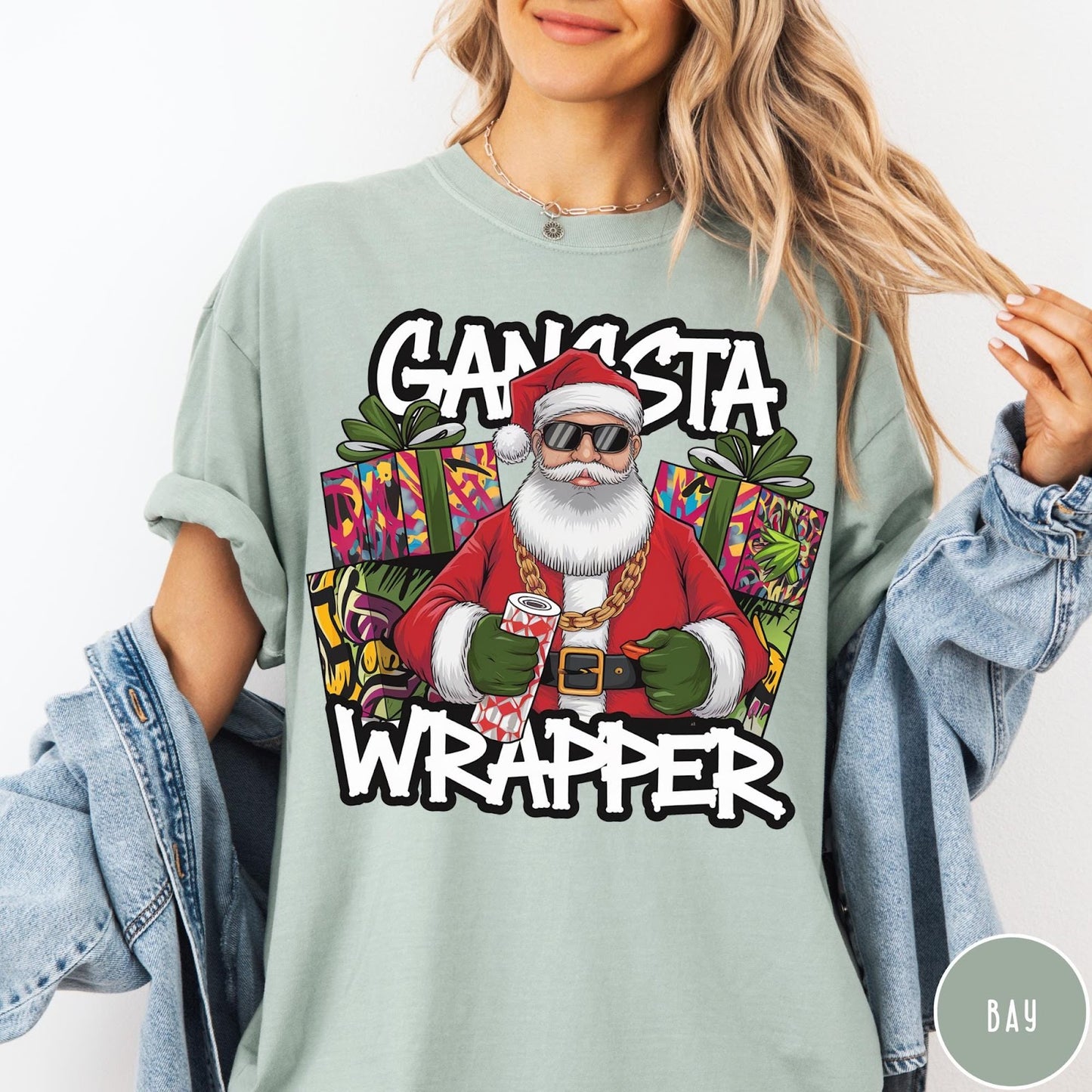 Comfort Colors tee in Bay featuring cartoon style Santa Claus wearing sunglasses and gold chain holding wrapping paper