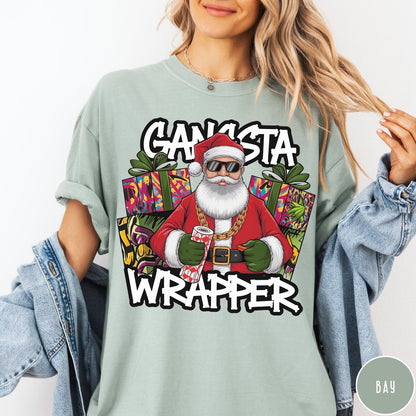Comfort Colors tee in Bay featuring cartoon style Santa Claus wearing sunglasses and gold chain holding wrapping paper