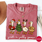 Comfort Colors tee in Crimson featuring festive geese graphic with Santa, Christmas tree, reindeer, and gingerbread goose designs