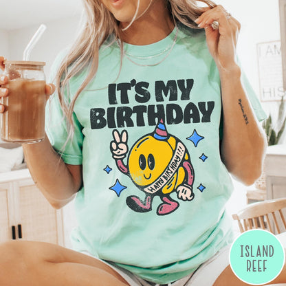 Comfort Colors tee in Island Reef featuring retro birthday mascot graphic with peace sign and party hat