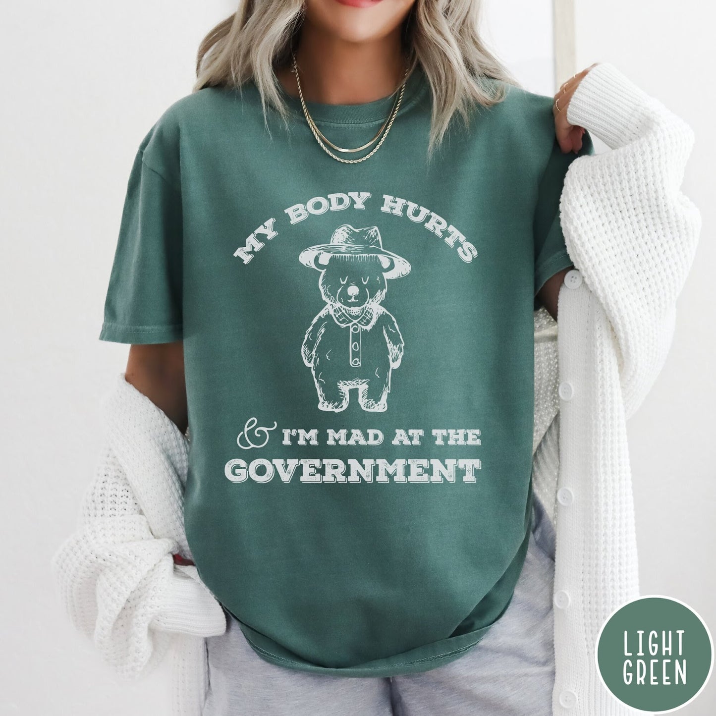 Comfort Colors tee in Light Green featuring line art style bear wearing a hat and button-up shirt graphic
