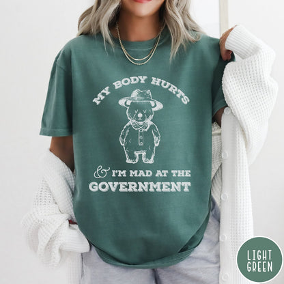 Comfort Colors tee in Light Green featuring line art style bear wearing a hat and button-up shirt graphic
