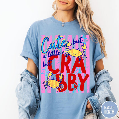 Comfort Colors tee in Washed Denim featuring playful graphic text and yellow crab illustrations with pink stripes