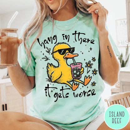 Comfort Colors tee in Island Reef featuring illustrated duck graphic wearing sunglasses and drinking a pink iced beverage