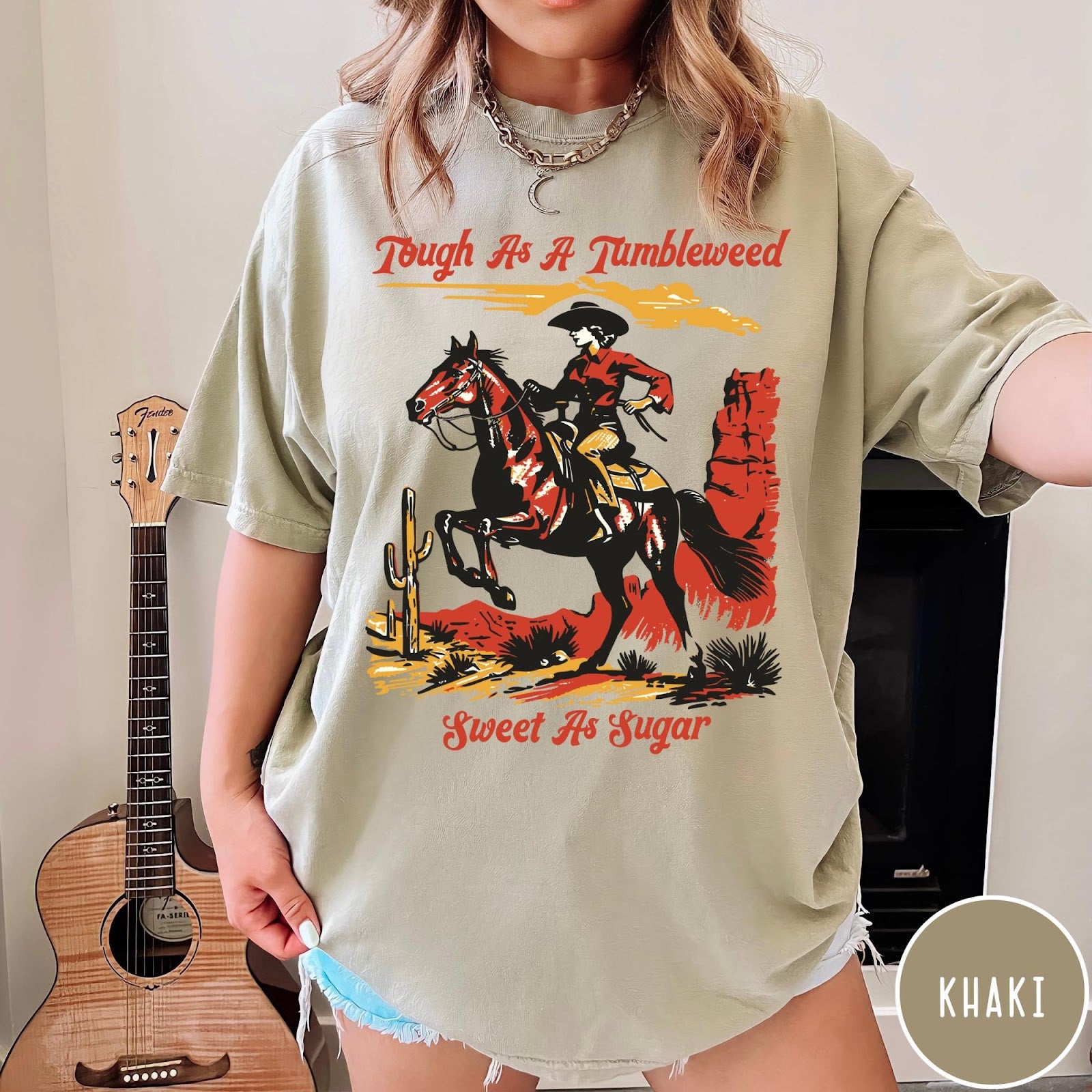 Comfort Colors tee in Khaki featuring western style graphic of a cowgirl riding a horse in desert