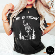 Comfort Colors tee in Black featuring graphic style Jesus playing basketball with mountains and pine trees illustration