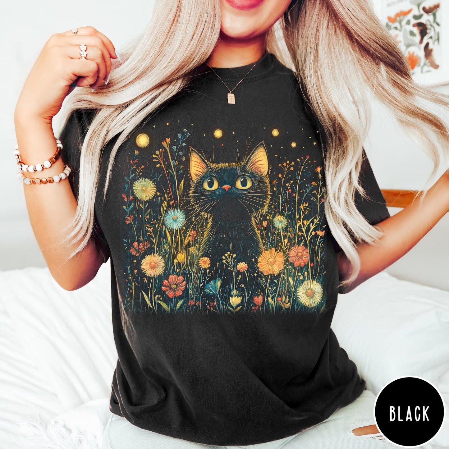 Comfort Colors tee in Black featuring artistic graphic of a black cat sitting in a flower field
